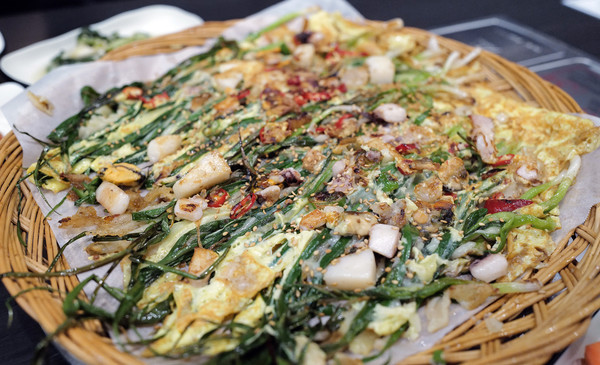 두툼한 해물이 듬뿍 들어가고 신선한 채소가 얇게 썰어져 독특한 해물전의 맛을 느낄 수 있다. 바닥에 깔린 얇은 튀김가루는 전의 동그란 모양을 유지시켜준다. 