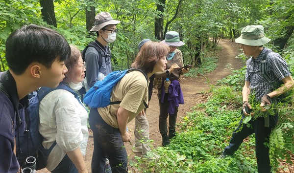 숲해설사 임철호(오른쪽)씨가 오송산 산책로에서 식물에 대해 설명하고 있다.
