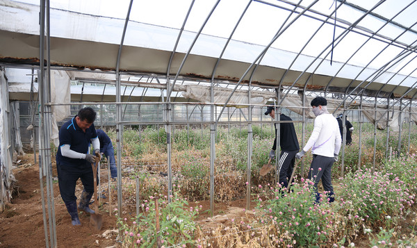 큰 비로 수해를 입은 농가의 조합원과 피해복구를 하는 농협 직원들.