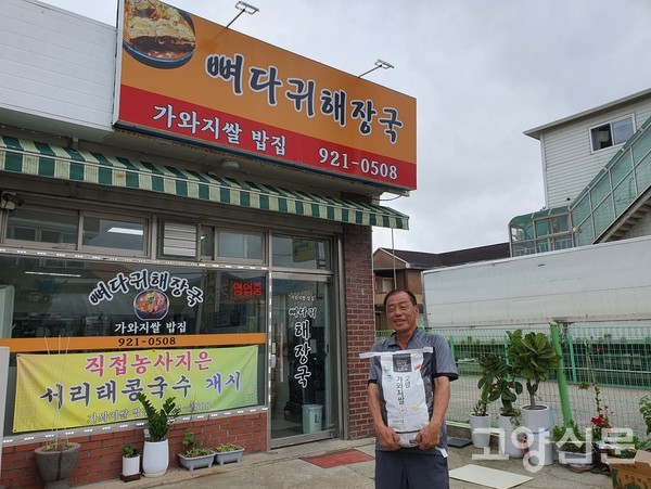 김명선 대표가 직접 농사한 가와지1호 품종쌀들 들고 음식점으로 들어가고 있다.