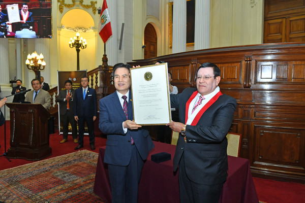 알레한드로 소토 레예스 페루 국회의장(오른쪽)이 하나님의교회 총회장 김주철 목사(왼쪽)에게 국회 훈장을 수여하고 있다.