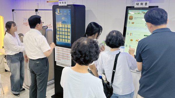 키오스크를 조작하는 참가자들.