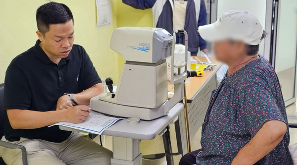  고양신세계안과 직원이 무료 안과검사를 하고 있다.