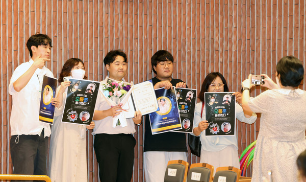 동료를 축하하며 사진촬영을 하는 복지관 직원들.