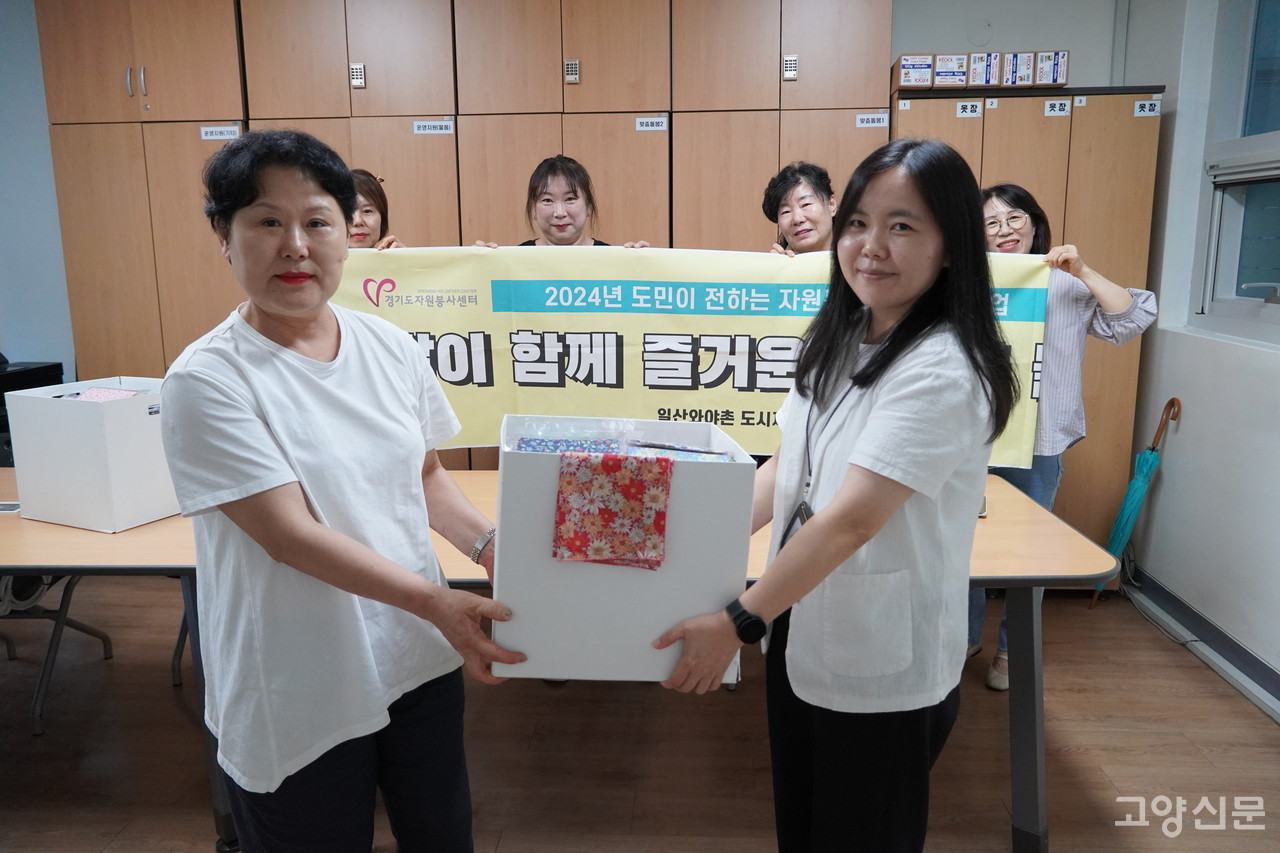 이경희 대표(왼쪽)가 대화노인종합복지관에 스카프와 에코백을 전달하고 있다.