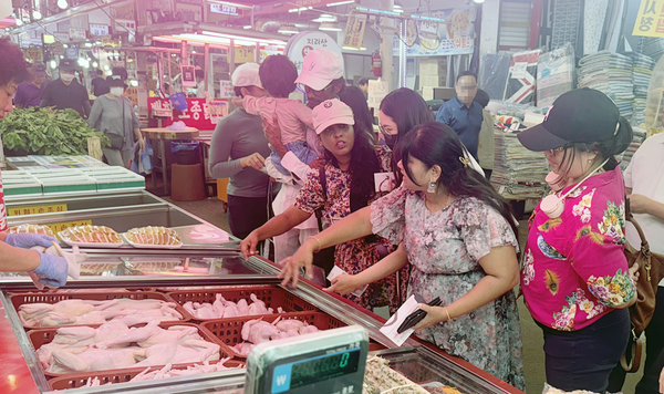 다문화가족이 전통시장 체험을 하고 있다.