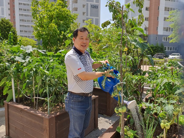 고령의 어르신들이 가꾸는 텃밭화분에 이백래 관리소장이 물을 주고 있다.