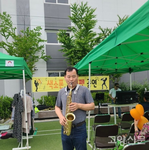 지난 봄에 열린 원흥마을 바자회 행사에서 이백래 관리소장이 색소폰으로 '홍시'를 연주하고 있다.