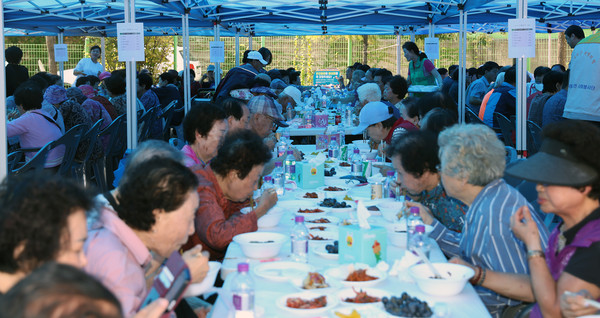 능곡동 경로잔치에서 어르신들이 음식을 즐기고 있다.