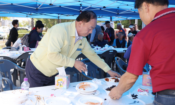 장순복 지도농협 조합장이 어르신들이 다 드신 음식물을 치우고 있다.