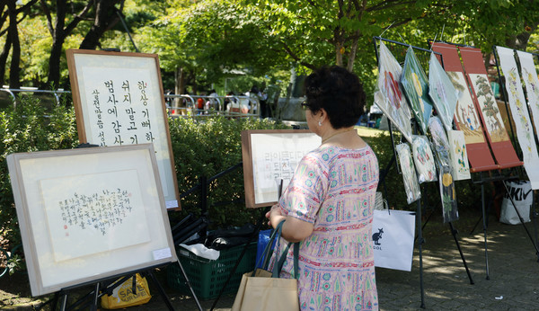 중산1동 마을축제에서 한 시민이 전시품을 보고 있다.