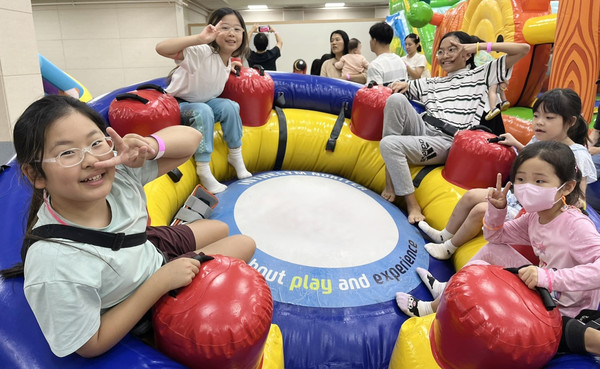  아이들이 에어바운스를 이용해 재미있게 놀고 있다.
