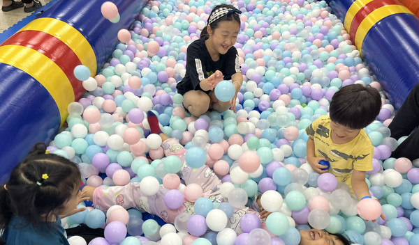 아이들이 볼풀장에서 마을축제를 즐기고 있다.
