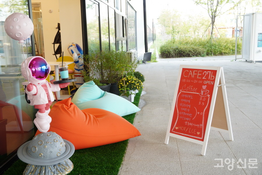 음료 쟁반을 받쳐 든 우주인이 반갑게 맞아주는 카페 입구. 