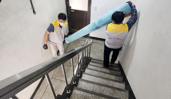 한국동서발전 일산발전본부 임직원들이 노후된 장판을 나르고 있다. [사진제공=한국동서발전]