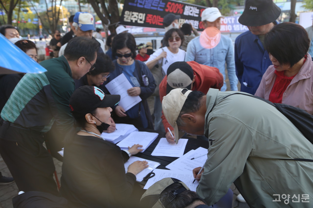 이날 집회장소 한켠에서는 일산의 연립주택 주민들이 170% 기준용적률의 부당성이 기술된 ‘고양시 노후계획도시 정비기본계획’ 공람 의견서에 서명하고 있다.
