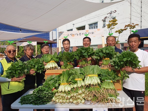 참석자들이 일산열무와 얼갈이를 농촌지도자회 농산물마켓에서 보여주고 있다.