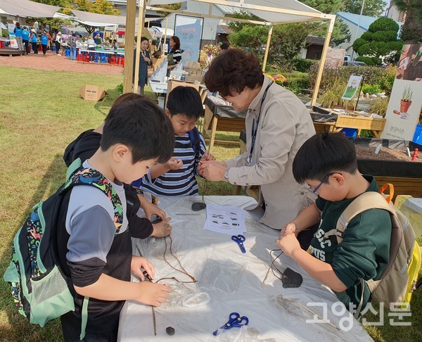 초등학생들이 진지하게 '반달돌칼 만들기'를 하고 있다.