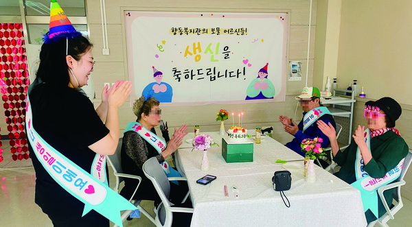 ‘푸른달열엿새베이커리’가 후원한 생일케이크를 앞에 두고 생신축하 노래를 부르고 있다.