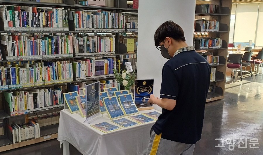 한강 작가 북큐레이션을 관심 있게 관람하는 청소년 독자. 