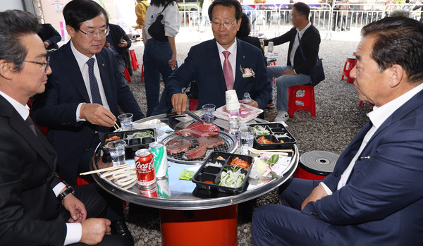 유완식 조합장과 관계자들이 한우를 구우며 축제 이야기를 하고 있다.