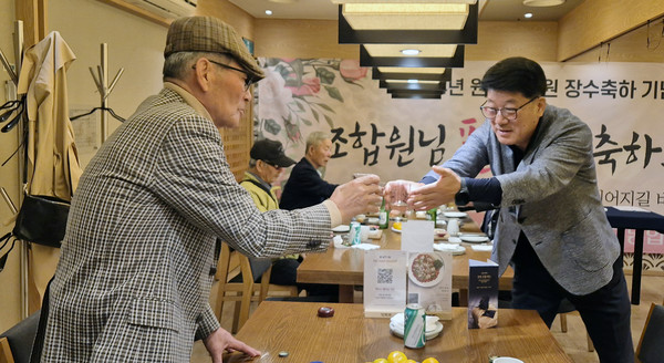 심은보 송포농협 조합장(오른쪽)이 건강과 장수를 기원하며 조합원에게 인사를 하고 있다.