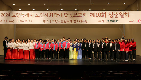 노인사회참여 활동보고회에서 많은 참여자들이 단체사진을 찍고 있다.