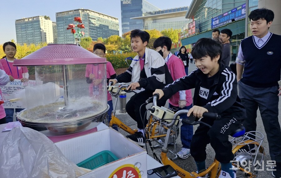 자전거로 전기를 만들어 솜사탕 기계를 돌리고 있는 참가 어린이. 