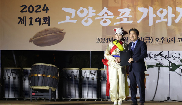  김운남 고양시의회의장(오른쪽)이 권슬기 고양송포호미걸이 사무국장(왼쪽)에게 이기헌 국회의원 명의의 표창장을 전달하고 있다.