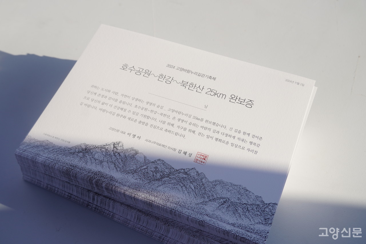 고양바람누리길 25km 완보증을 쌓아두고 도착할 참가자들을 맞이할 준비를 한다. 