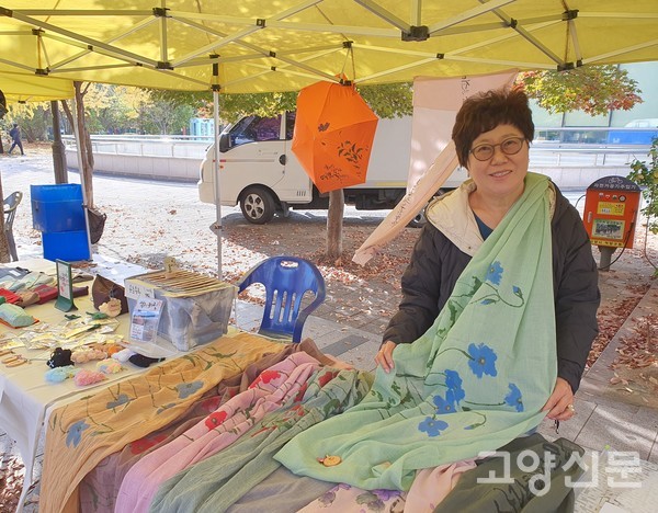덕양구청 옆 가로수길에서 열린 공유마켓에서 천 아트(스카프에 캘리그라피와 그림)를 보여주고 있다.