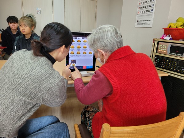 키오스크 주문하기를 직접 해보는 어르신.