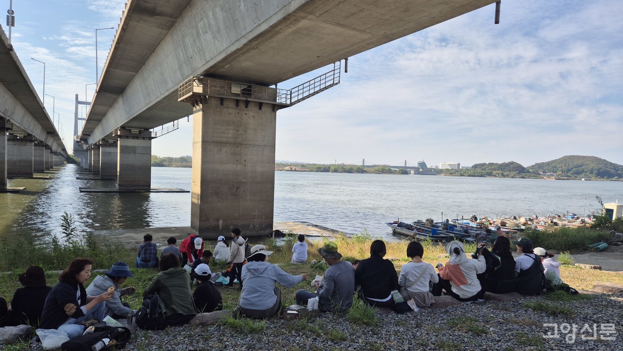 행주대교 아래, 한강을 바라보며 완주배지와 간식을 받은 참가자들이 자리를 잡고 앉았다.