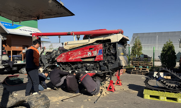 여럿이 함께 농기계를 손보고 꼼꼼히 체크하며 안전한 농기계를 위해 수리를 하고 있다.