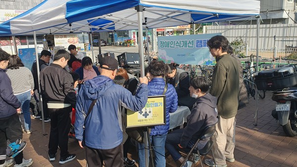 주민들이 보완대체 의사소통(AAC) 체험과 장애인식개선 캠페인에 참여하고 있다.