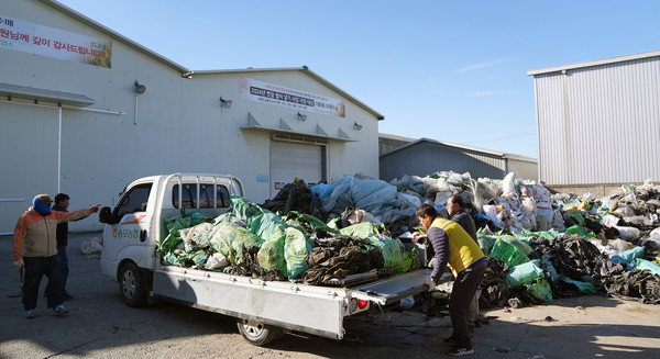 농민들이 가져온 폐농자재를 내리는 환경정화 활동 관계자들.