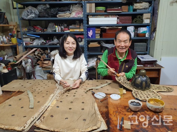 박성규씨(오른쪽)와 딸 박선영 공동대표가 조선시대 장군 옷(갑옷과 모자) 복원하는 작업을 보여주고 있다.