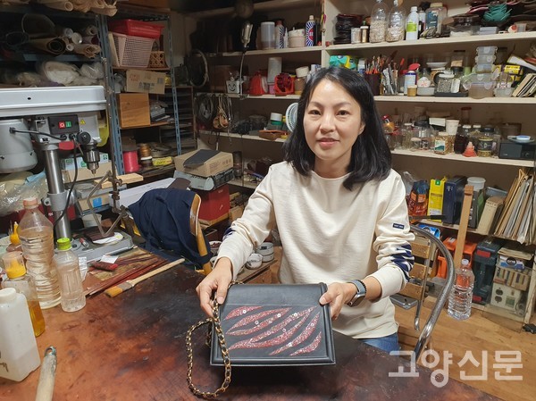 가죽핸드백. 앞쪽에 작은 꽃잎이 흩날리는 모습을 나전으로 표현했다.