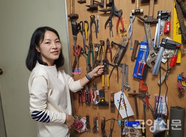 박선영 대표가 오래된 공구걸이판에서 자개문양 자를 때 사용하는 실톱을 찾고 있다.