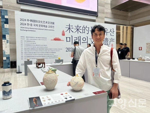 지난 9월 한·중 국제문화교류전에서 윤주철 대표가 첨장기법 작품 앞에 서 있다.