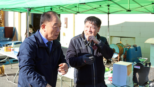  장순복 지도농협 조합장(왼쪽)이  진성종 경제상무와 벼 수매와 관련해  현장에서 이야기를 나누고 있다.