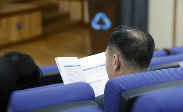 설명회 책자를 보며 설명회를 경청하는 한 참석자.