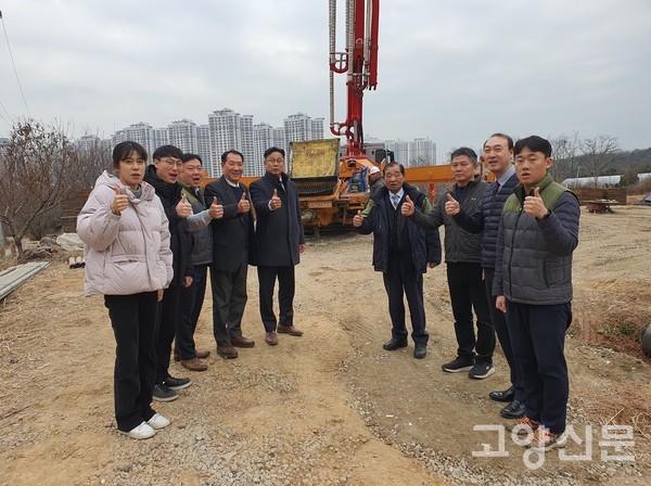 김보연 조합장과 직원들이 콘크리트를 바닥 전체에 붓는 작업을 하는 펌프카를 배경으로 '무재해'를 외치고 있다.