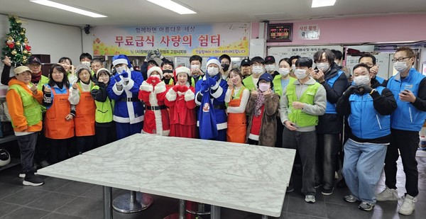 봉사자들이 무료 급식 후 단체사진 촬영을 하고 있다.