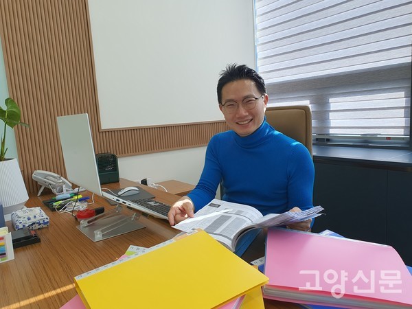 강해운 관리단장이 자료를 살펴보다가 밝게 웃고 있다.