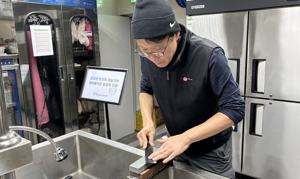  김대현씨가 칼을 가는 봉사를 하고 있다.