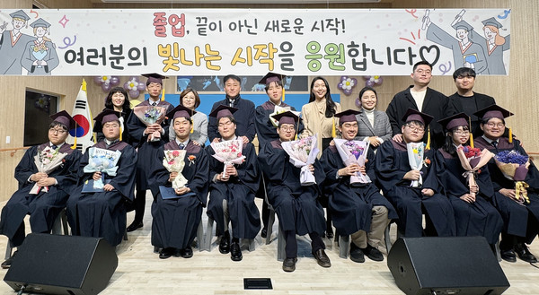 학생들과 졸업사진을 찍고 있는 교사들.