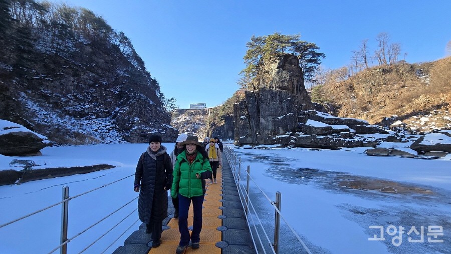 꽁꽁 언 강물 위를 부교를 따라 걷는 한탄강 물윗길 트레킹. 뒤쪽 우뚝 솟은 바위가 한탄강 고석이다.  [사진=박경만 전문기자]