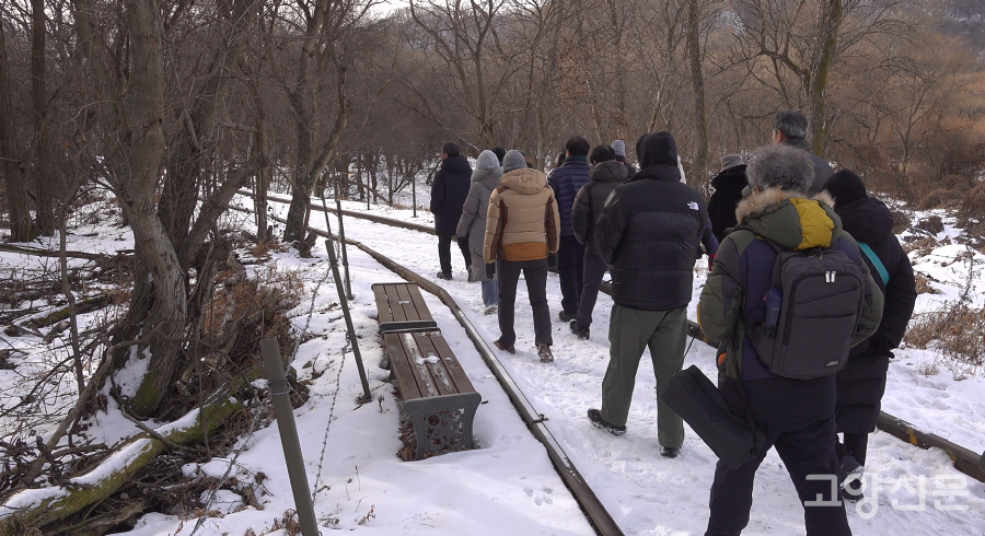 눈 덮인 철길을 따라 걷는 탐방객들.
