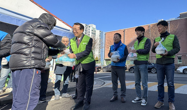 유완식 조합장과 참가자들이 어르신들에게 떡국과 생활용품을 전달하고 있다.